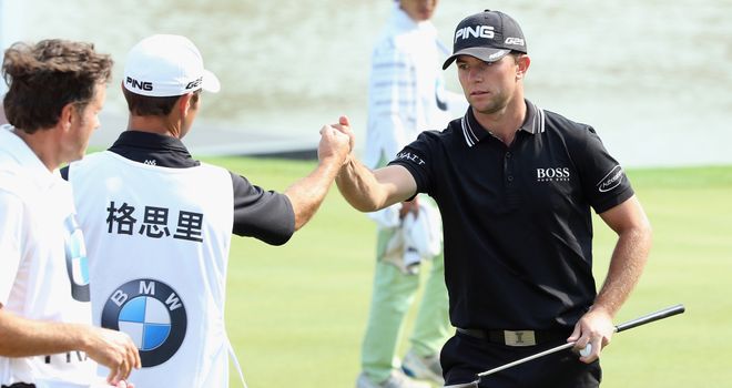 Luke Guthrie celebrates with his caddie after his opening 65