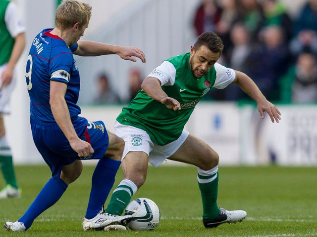 Richie Foran left challenges Hibernian's Tom Taiwo
