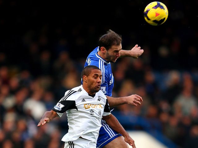 Branislav Ivanovic and Wayne Routledge go for a high ball