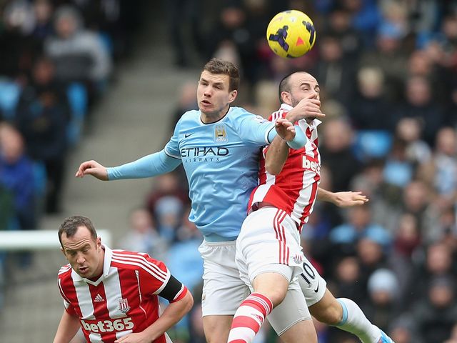Marc Wilson of Stoke City in action with Edin Dzeko of Man City