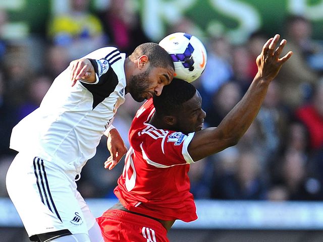 Victor Anichebe and Ashley Williams go for a header