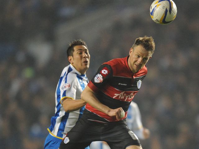 Clint Hill heads the ball away from Leonardo Ulloa