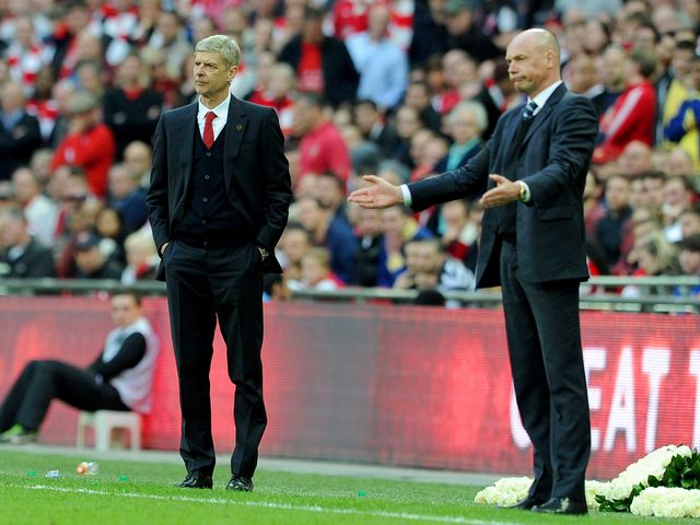 Arsene Wenger and Uwe Rosler watch the action