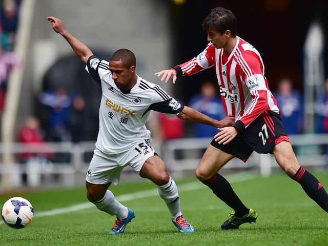 Santiago Vergini keeps track of Wayne Routledge