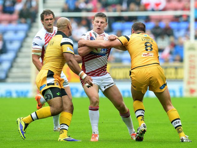 George Williams is tackled by Jake Webster and Andy Lynch