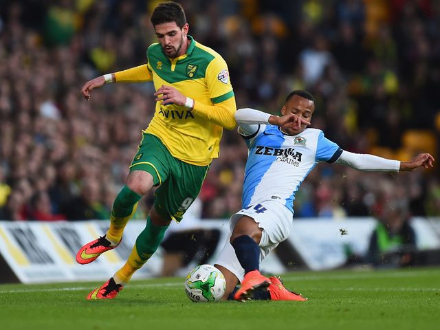 Kyle Lafferty of Norwich City battles with Marcus Olsson of Blackburn