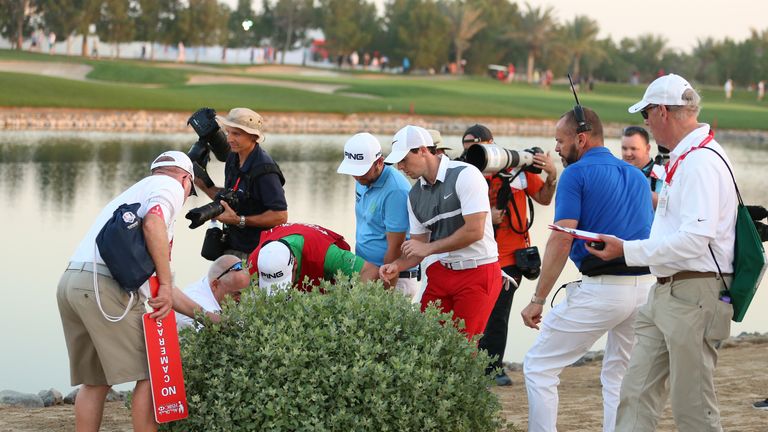 McIlroy helps Andy Sullivan hunt for his ball at the ninth, but DeChambeau did not join the search party
