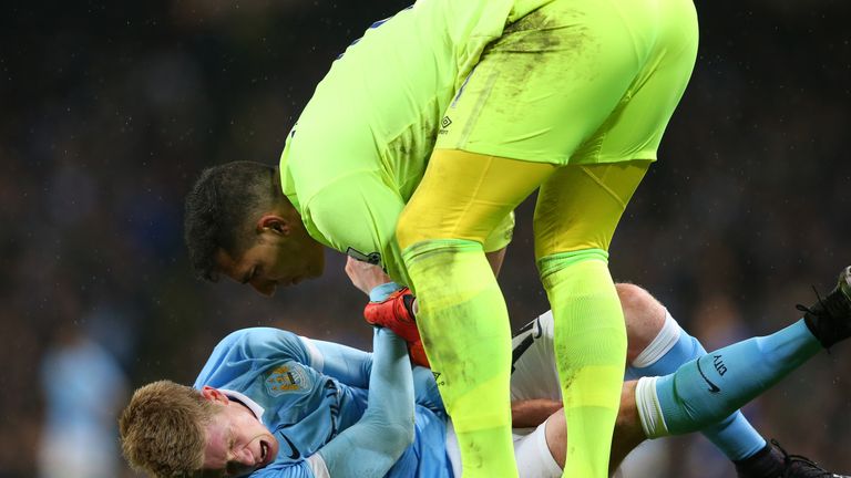 Goalkeeper Joel Robles of Everton attempts to assist the injured Kevin De Bruyne of Manchester City