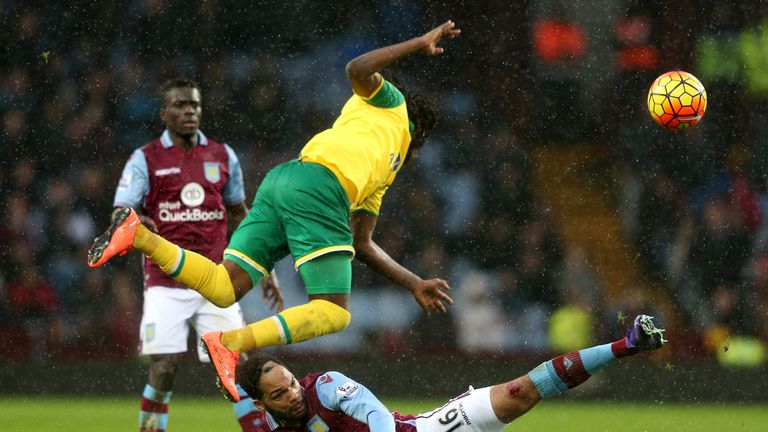 Dieumerci Mbokani of Norwich City is tackled by Joleon Lescott of Aston Villa