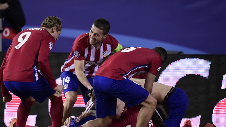 Atletico Madrid players mob Juanfran after his penalty secured victory against PSV