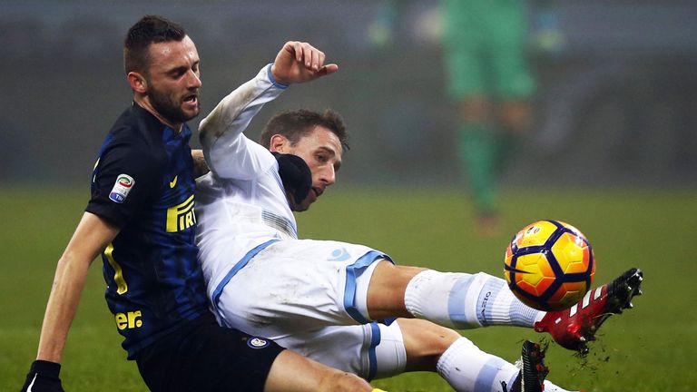 Inter Milan midfielder Marcelo Brozovic (left) fights for the ball with Lucas Biglia