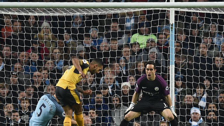 Theo Walcott scores his team's first goal past Manchester City's Chilean goalkeeper Claudio Bravo 