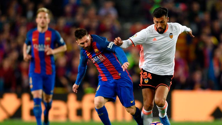 Lionel Messi (L) vies with Ezequiel Garay (R) during Barcelona's win over Valencia