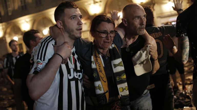 One Juventus supporter is helped from the Piazza San Carlo on Saturday night