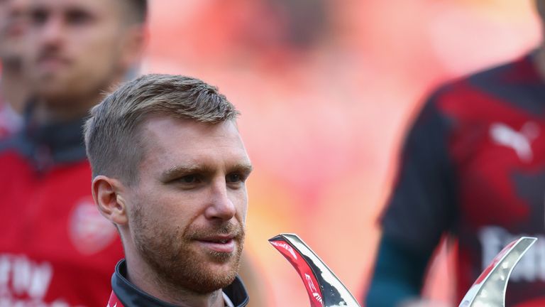 Per Mertesacker holds the Emirates Cup after Arsenal claimed the trophy for a fifth time