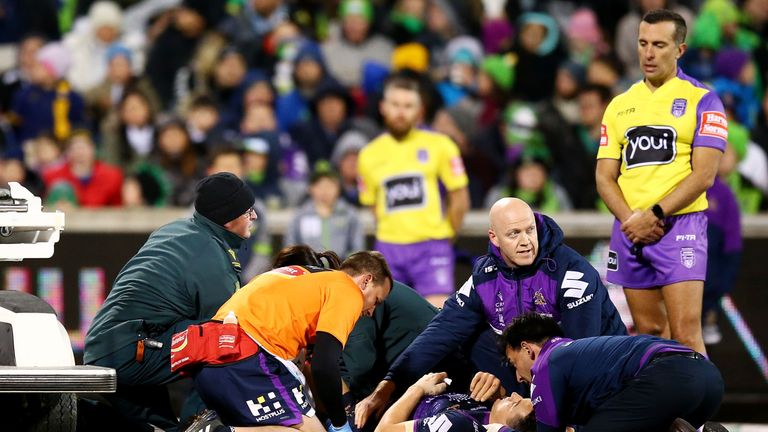 Billy Slater receives treatment after a tackle by Canberra's Sia Soliola
