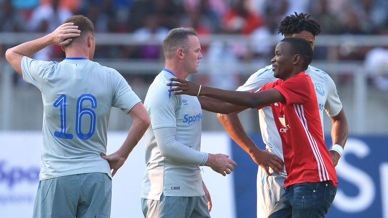 Wayne Rooney is hugged by a Manchester United fan in Tanzania during Everton's friendly