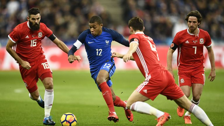 Kylian Mbappe takes on Joe Ledley and Ben Davies at the Stade de France