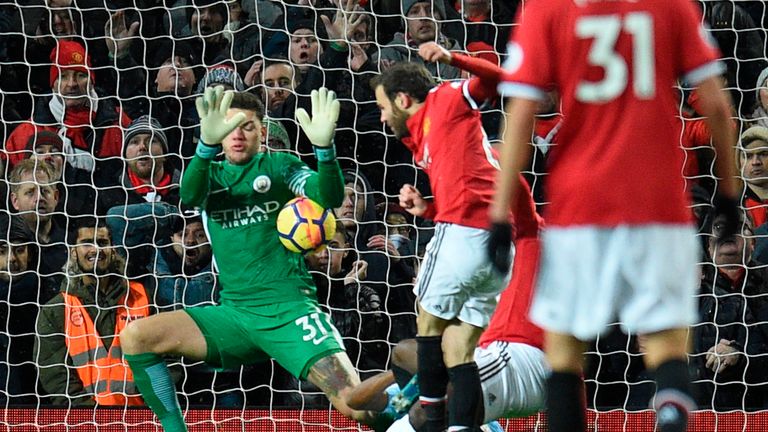 Man City 'keeper Ederson (left) prevents Juan Mata from equalising late on