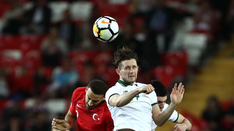 Alan Browne and Cenk Tosun go up for the ball during the match