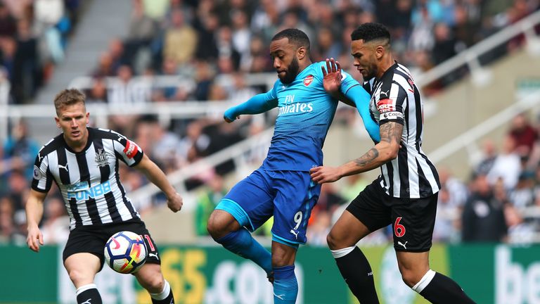 Arsenal's Alexandre Lacazette battles for the ball with Newcastle defender Jamaal Lascelles