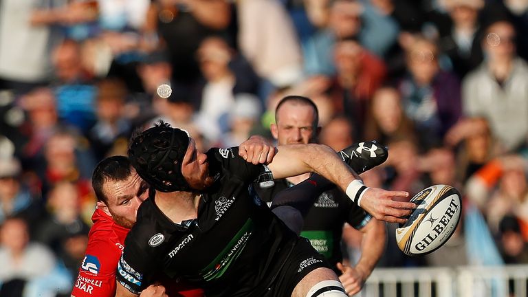 Tim Swinson of Glasgow Warriors is tackled by Rob Evans of Scarlets