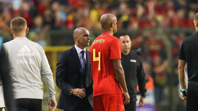 Roberto Martinez speaks with Vincent Kompany as he leaves the pitch through injury