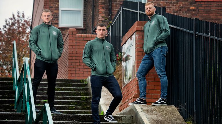 Super League: Wigan Warriors look to future with radical new badge - Dom Manfredi, Harry Smith and Joe Bullock model some of Wigan's new leisurewear range at the Blind Steps