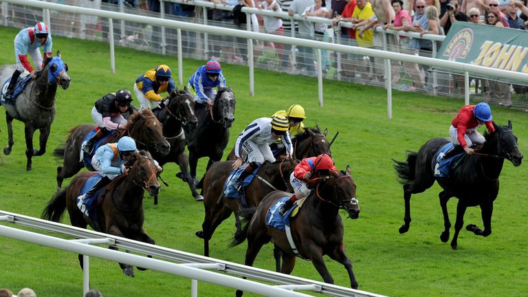 Take Cover ridden by Andrea Atzeni (centre, red silks) wins the John Smith's City Walls Stakes.