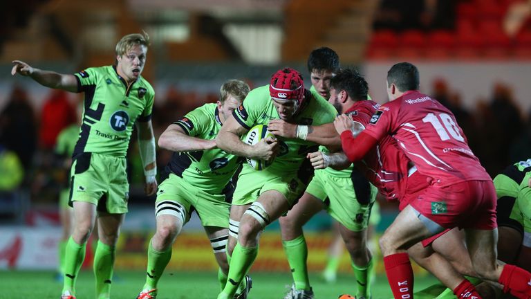 Christian Day of Northampton Saints is held up by Rory Pitman of Scarlets