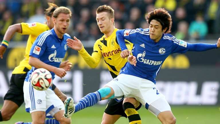 Marco Reus of Dortmund battles for the ball with Atsuto Uchida
