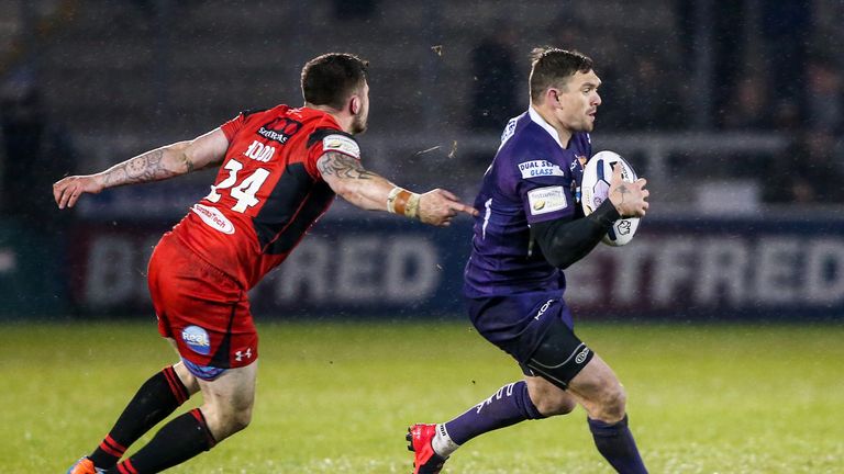 Huddersfield's Danny Brough escapes the tackle of Salford's Liam Hood.
