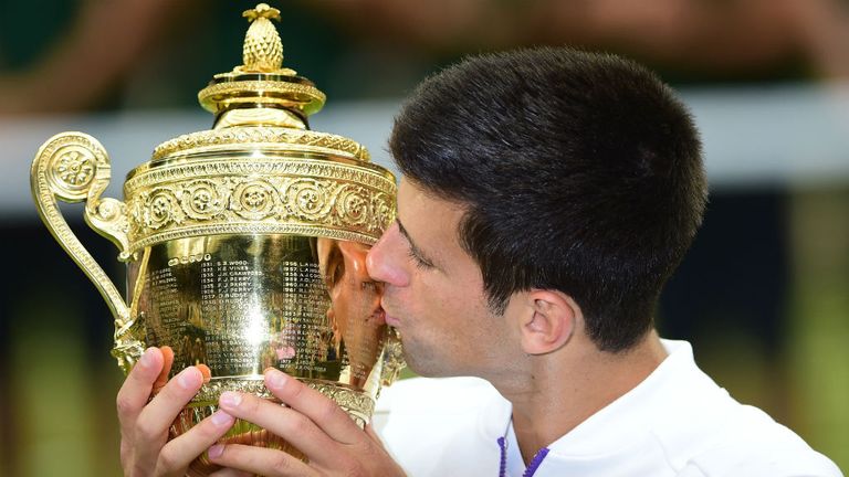 Djokovic celebrates with the trophy after beating Federer