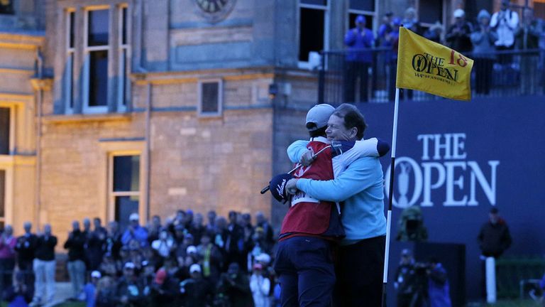 Watson (R) hugs his caddie, son Michael on the 18th green