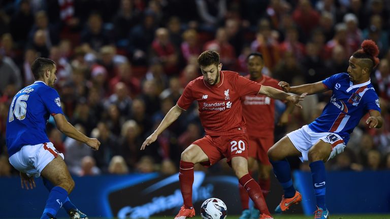 Liverpool's Adam Lallana (2nd L) vies with Carlisle United's Gary Dicker and Carlisle United's Bastien Hery (R)