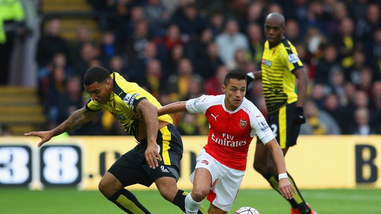 Sanchez and Troy Deeney compete for the ball in the first-half at Vicarage Road