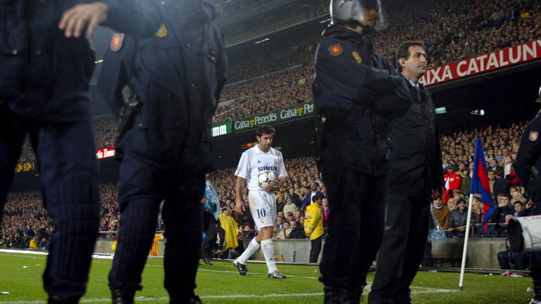 Figo prepares to take a corner with a police escort during the match between Barcelona and Real Madrid