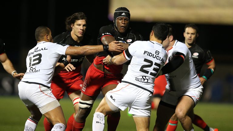 Maro Itoje is tackled by Toulouse duo Yann David (right) and Gael Fickou