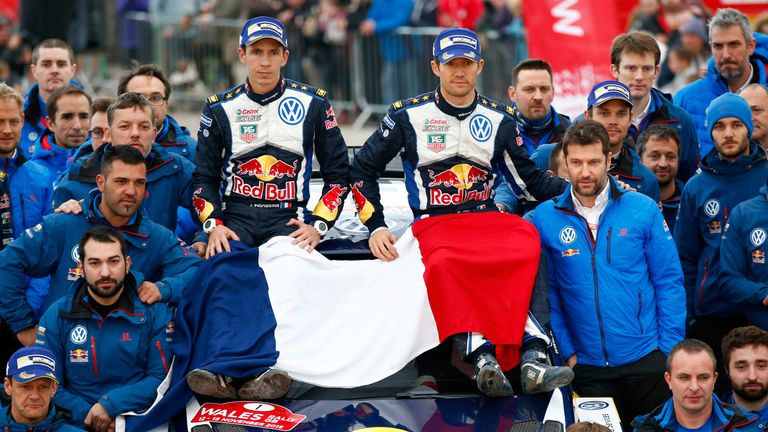 Sebastien Ogier and his co-driver Julien Ingrassia of France and Volkswagen Motorsport team members pay their respects with the French flag