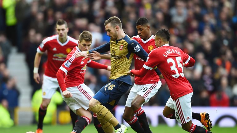 Aaron Ramsey of Arsenal is closed down by Rashford and Jesse Lingard