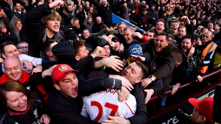 Divock Origi is mobbed by Liverpool fans after scoring.