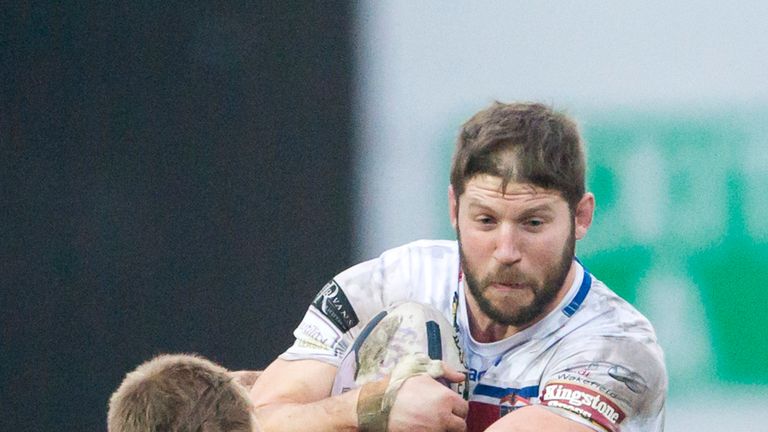 Wakefield's Nick Scruton fends off Hull KR's Keal Carlile.