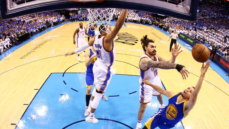 Stephen Curry of the Golden State Warriors goes up against Steven Adams of the Oklahoma City Thunder