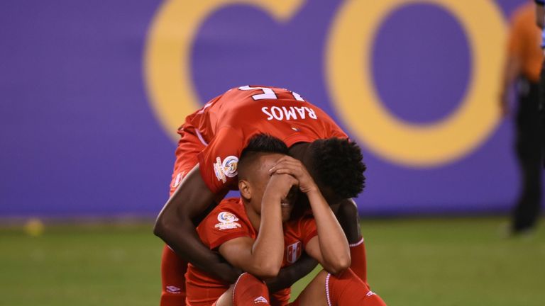 Peru's Christian Cueva (sitting) is comforted by Christian Ramos after firing the fourth penalty over the bar to send Colombia through