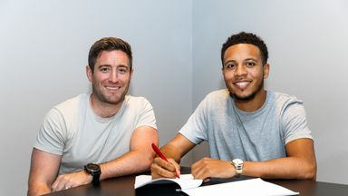 Image of Korey Smith (right) signs his new contract next to head coach Lee Johnson