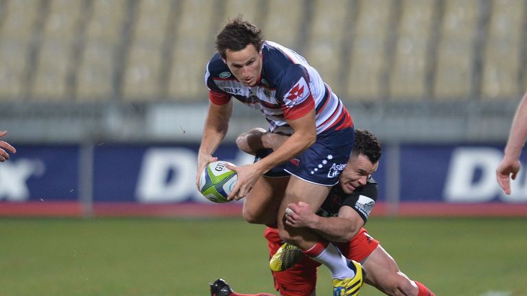 Tom English of the Rebels is tackled by Ryan Crotty of the Crusaders