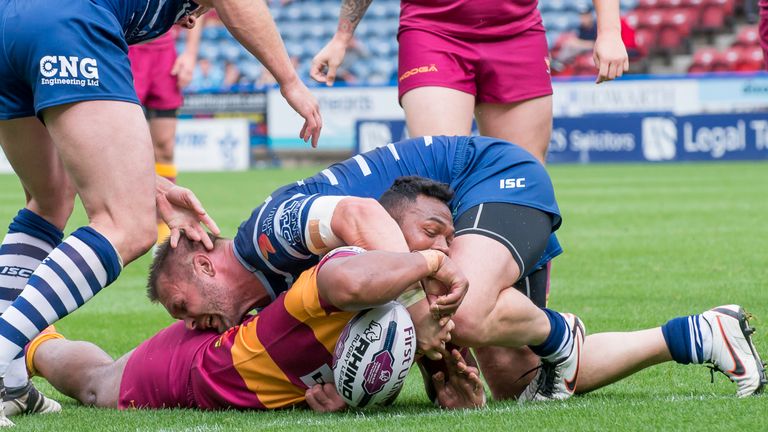 Huddersfield's Ukuma Ta'ai touches down for a try as Featherstone's Darrell Griffin attempts to hold him up