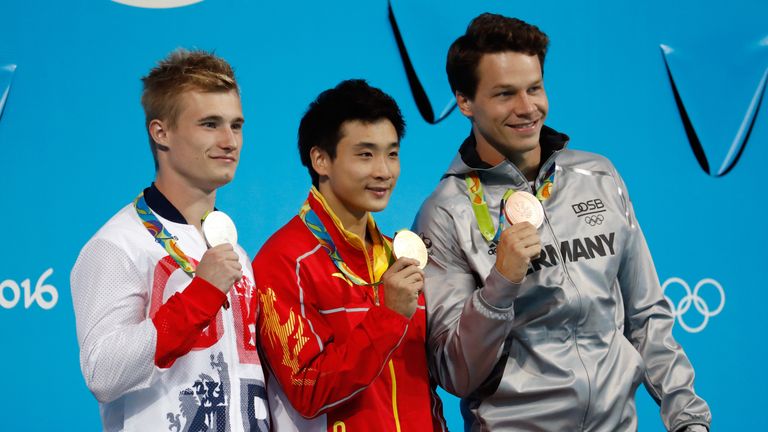 Jack Laugher (left) with his silver medal, with gold medalist Yuan Cao (centre) and Patrick Hausding