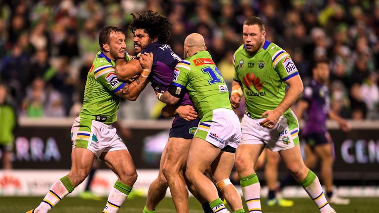 Tohu Harris is tackled by Canberra duo Josh Hodgson (left) and Kurt Baptiste