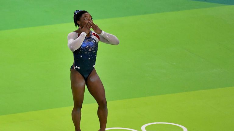 Simone Biles applauds the fans after winning the gold medal in the women's individual all-around gymnastics